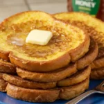 Assiette de pain perdu empilé avec une noisette de beurre fondant