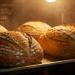 Pain brié avec une croûte croustillante cuisant au four, éclairés par une lumière chaude.