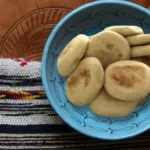 Batbouts marocains cuits et servis dans un bol bleu sur un tissu traditionnel