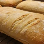 Pains ciabatta maison dorés et croustillants sortis du four, posés sur une grille