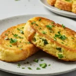 Deux tranches de pain perdu salé dorées, garnies de persil frais dans une assiette