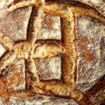 Pain Poilâne au levain, à la croûte dorée et grigné en forme de lettre stylisée