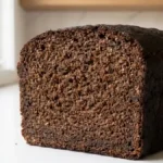 Pumpernickel allemand maison très sombre au seigle, présenté entier dans une cuisine lumineuse